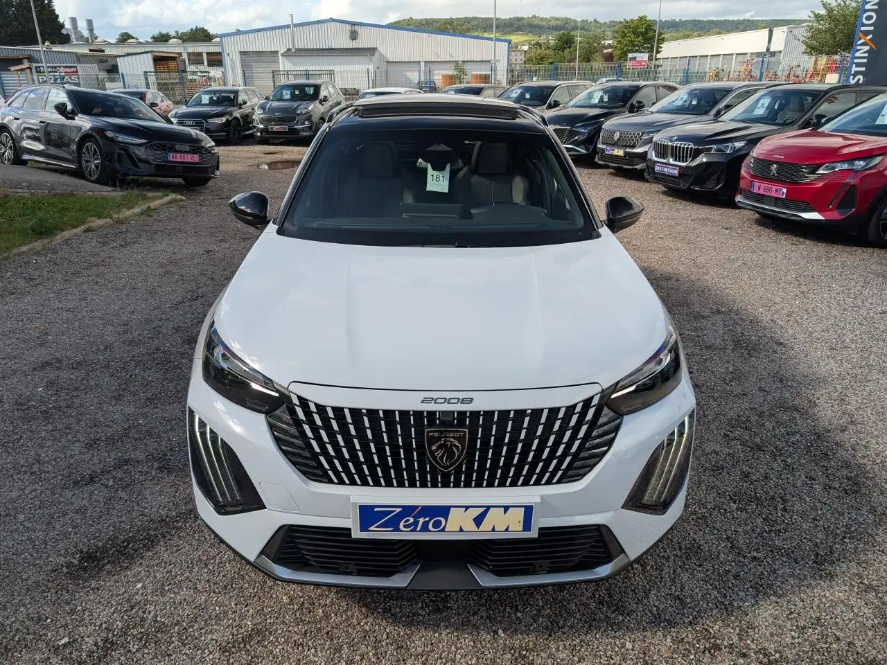 Vue avant d'un Peugeot 2008 blanc avec calandre noire à motifs verticaux et feux LED distinctifs en forme de griffes.
