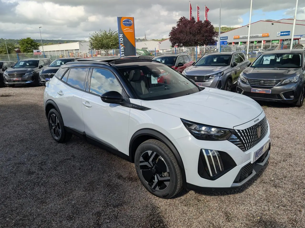 Peugeot 2008 GT hybride blanche vue 3/4 avant droit avec toit noir et jantes alliage bi-ton.