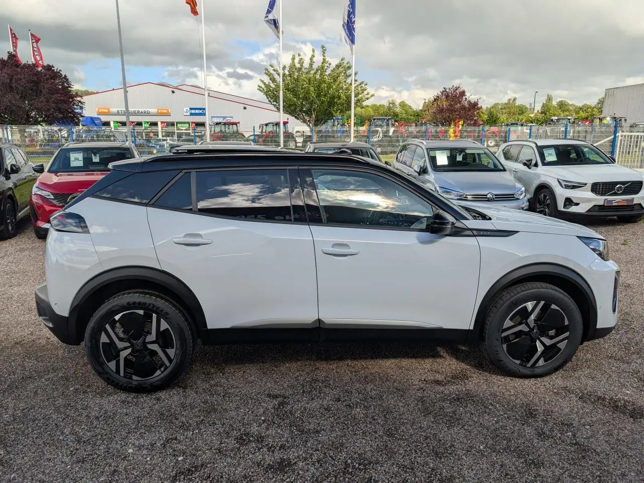 Peugeot 2008 blanc vue de profil côté gauche avec toit noir et jantes alliage bi-ton 17 pouces.