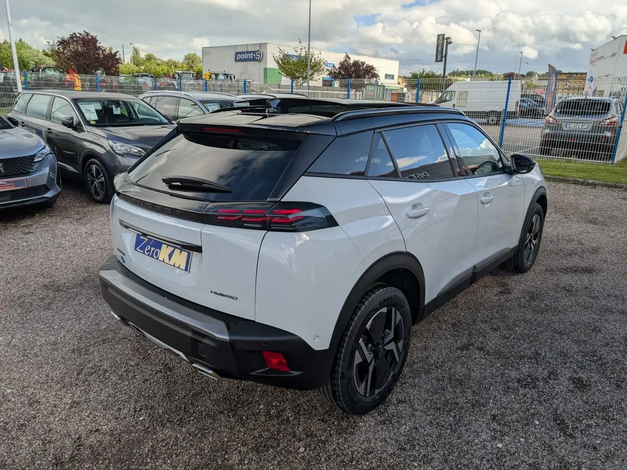 Vue 3/4 arrière droite du Peugeot 2008 blanc avec toit noir brillant et jantes alliage bi-ton.