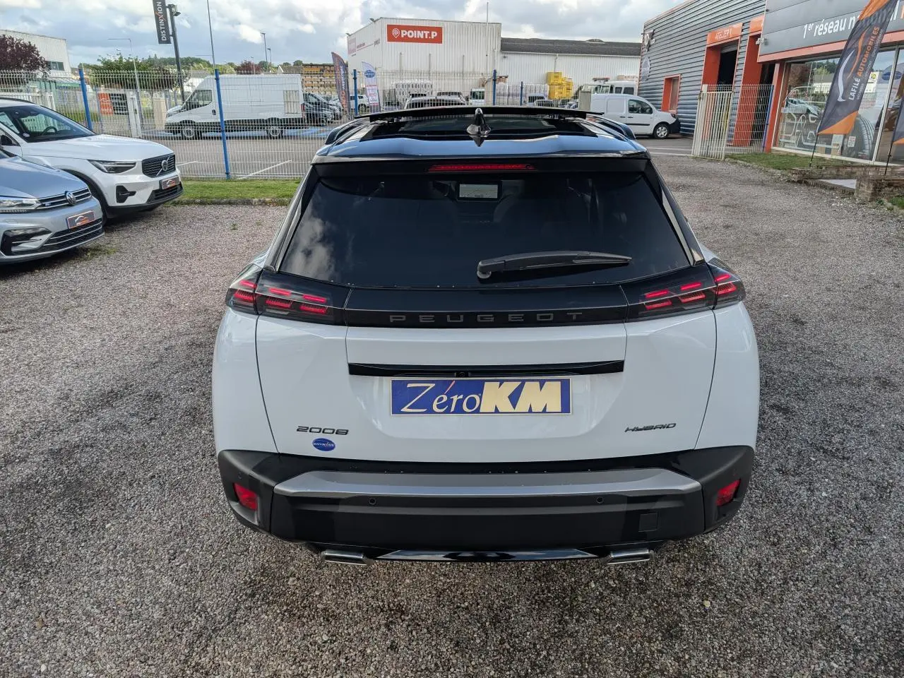 Vue arrière d’un Peugeot 2008 blanc hybride avec toit noir et feux arrière LED distinctifs en griffes.
