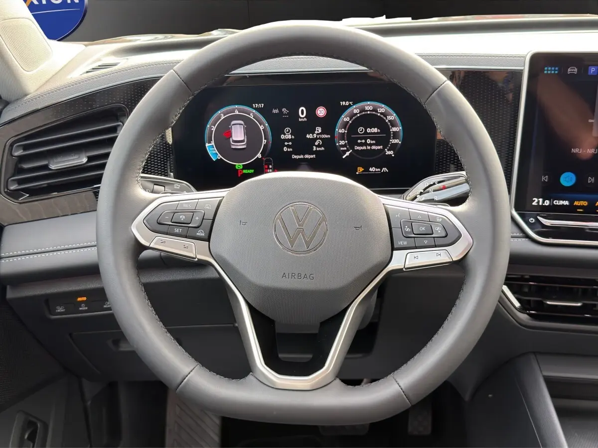 Vue intérieure centrée sur le volant cuir gris et le combiné d'instruments numérique du Volkswagen Tiguan 2026.