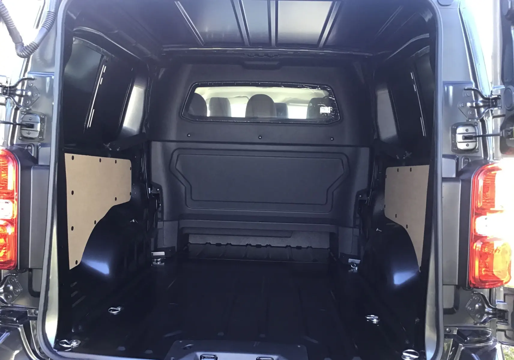 Coffre arrière ouvert du Peugeot Expert XL gris titane, vue intérieure montrant l’espace de chargement de 1,80 mètre.