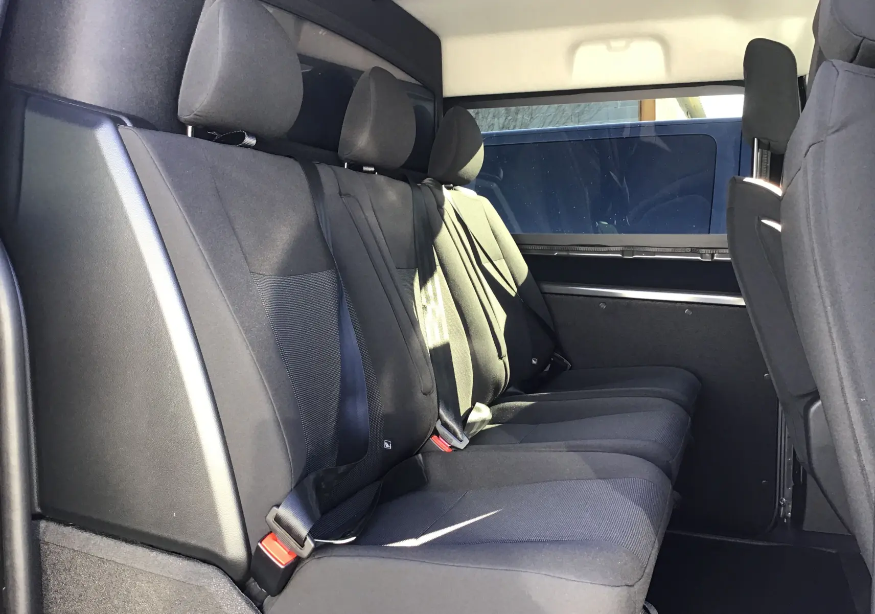 Profil côté droit du Peugeot Expert Cabine Approfondie gris titane 2025 avec porte coulissante ouverte révélant les sièges passagers.