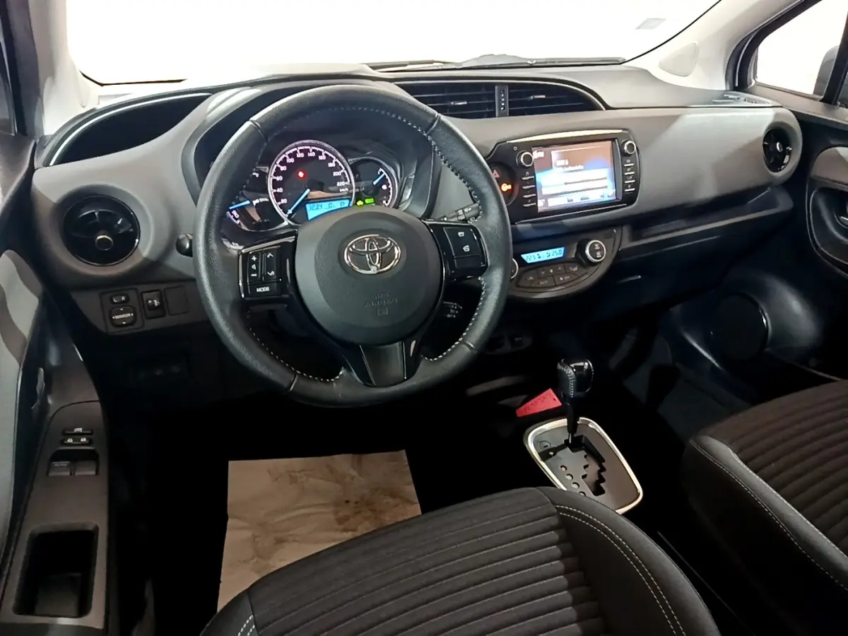 Intérieur de la Toyota Yaris 1.5 Hybrid 2019 vu de face, volant cuir multifonctions et écran tactile central.