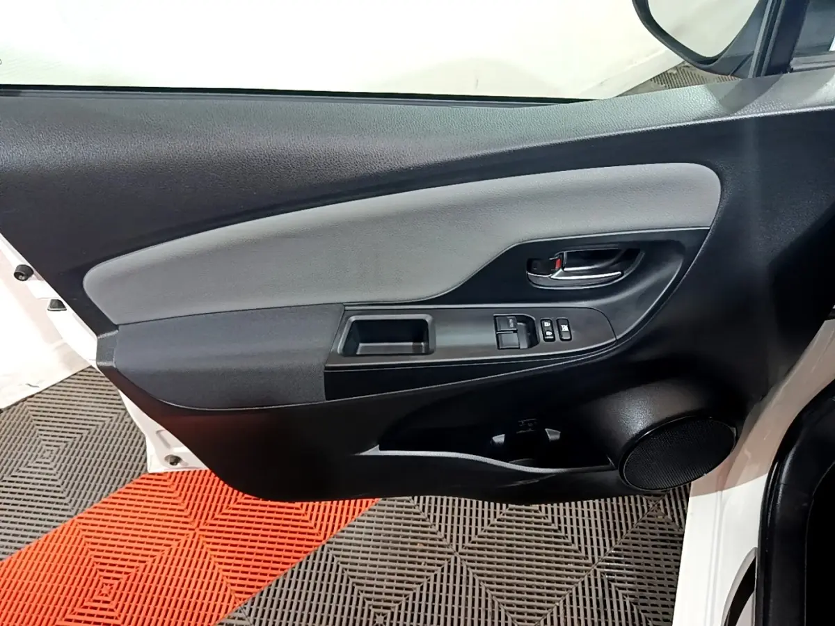 Intérieur côté gauche de la porte avant blanche de la Toyota Yaris 2019, avec commandes électriques et haut-parleur intégré.