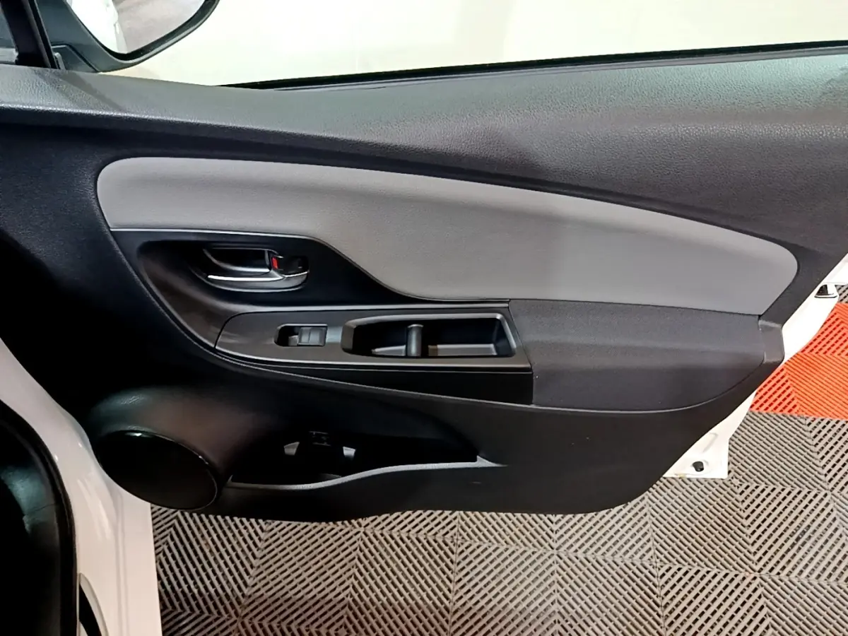 Gros plan sur la porte avant gauche blanche d'une Toyota Yaris 2019, avec panneau intérieur noir et gris.