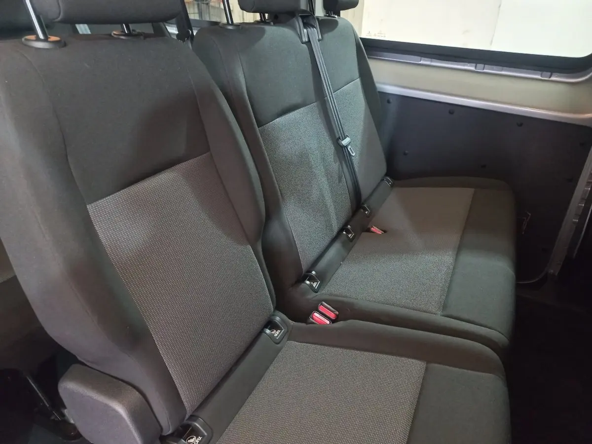 Vue intérieure côté droit sur la troisième rangée de sièges gris foncé du Peugeot Traveller 2021, banquette 3 places rabattable.