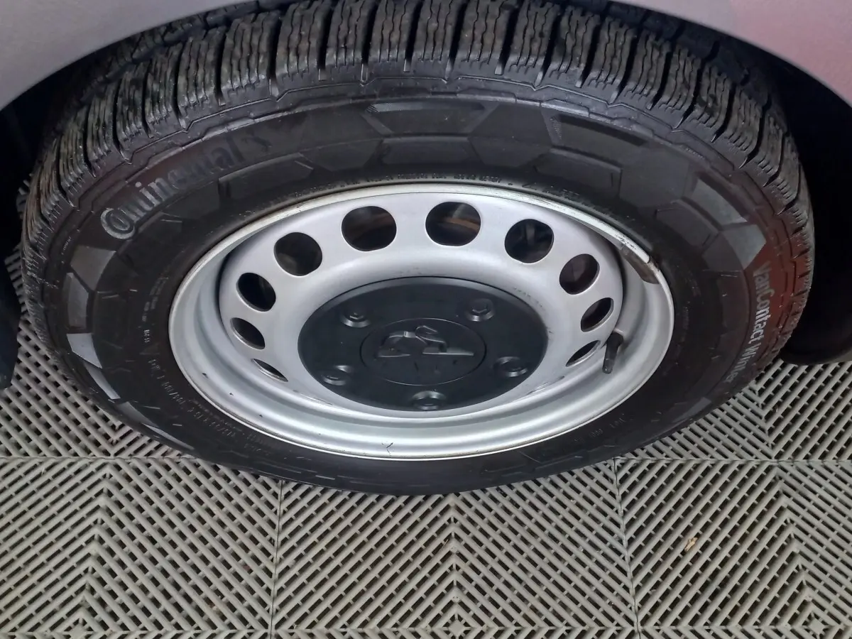 Gros plan sur la roue avant droite du Peugeot Traveller gris clair, mettant en valeur la jante acier et le pneu Continental.