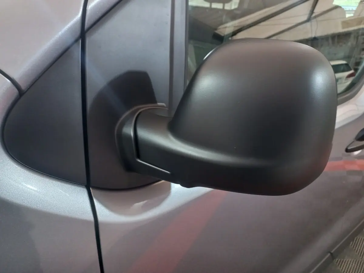Rétroviseur noir côté droit du Peugeot Traveller gris clair, vue rapprochée sur la portière avant.