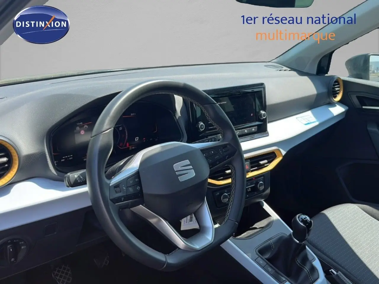 Vue intérieure avant de la SEAT Arona gris magnetic metal avec volant cuir multifonction et tableau de bord moderne.