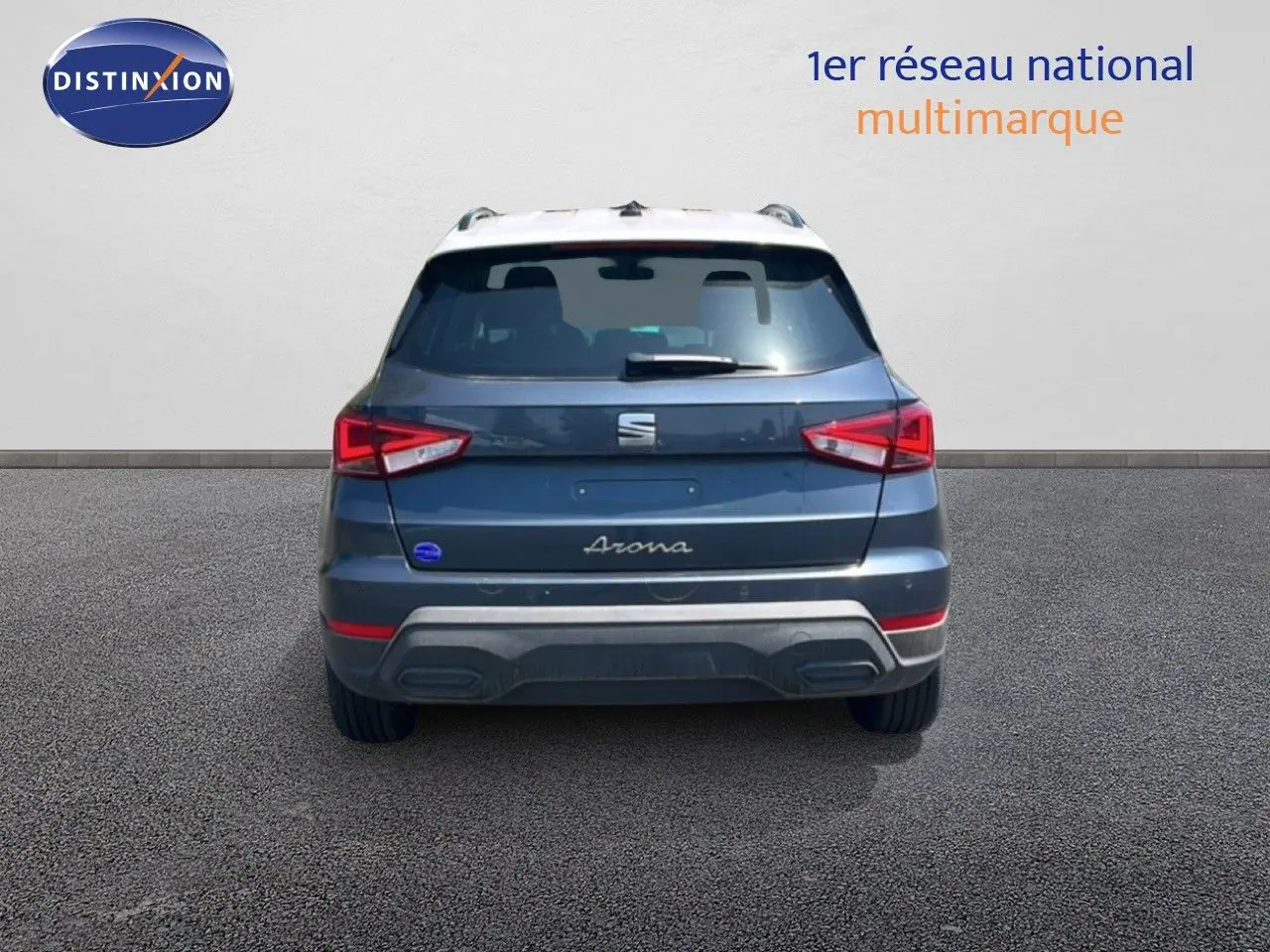 Vue arrière d'un SEAT Arona gris Magnetic Metal avec toit blanc, mettant en valeur ses feux arrière et son logo central.