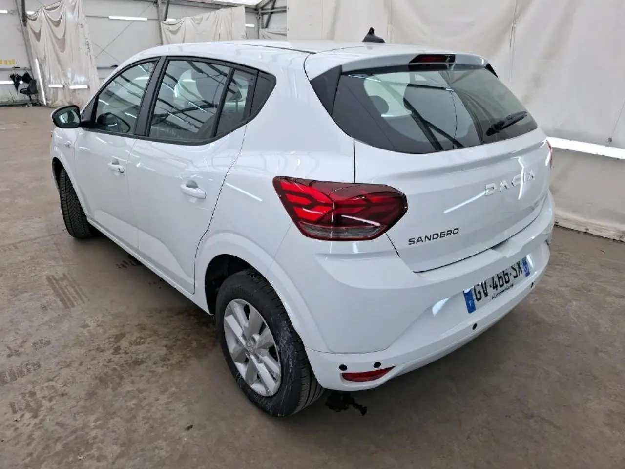 Vue 3/4 arrière droite d'une Dacia Sandero blanche 2024 avec feux LED et enjoliveurs Flex 15 pouces.
