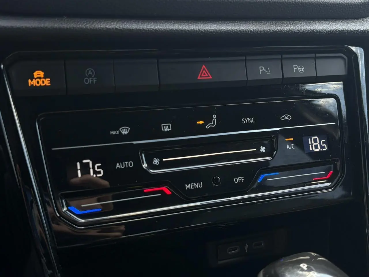 Gros plan sur la commande de climatisation bi-zone du Volkswagen T-Roc noir intense, avec affichage digital et boutons tactiles.