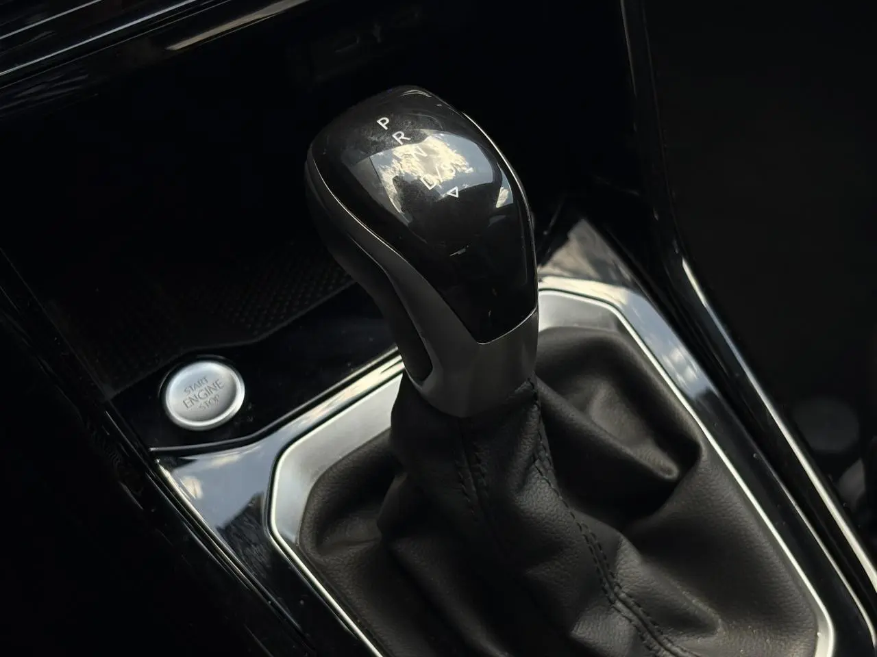 Le levier de vitesse automatique noir du Volkswagen T-Roc 2025 en gros plan avec bouton Start/Stop adjacent.