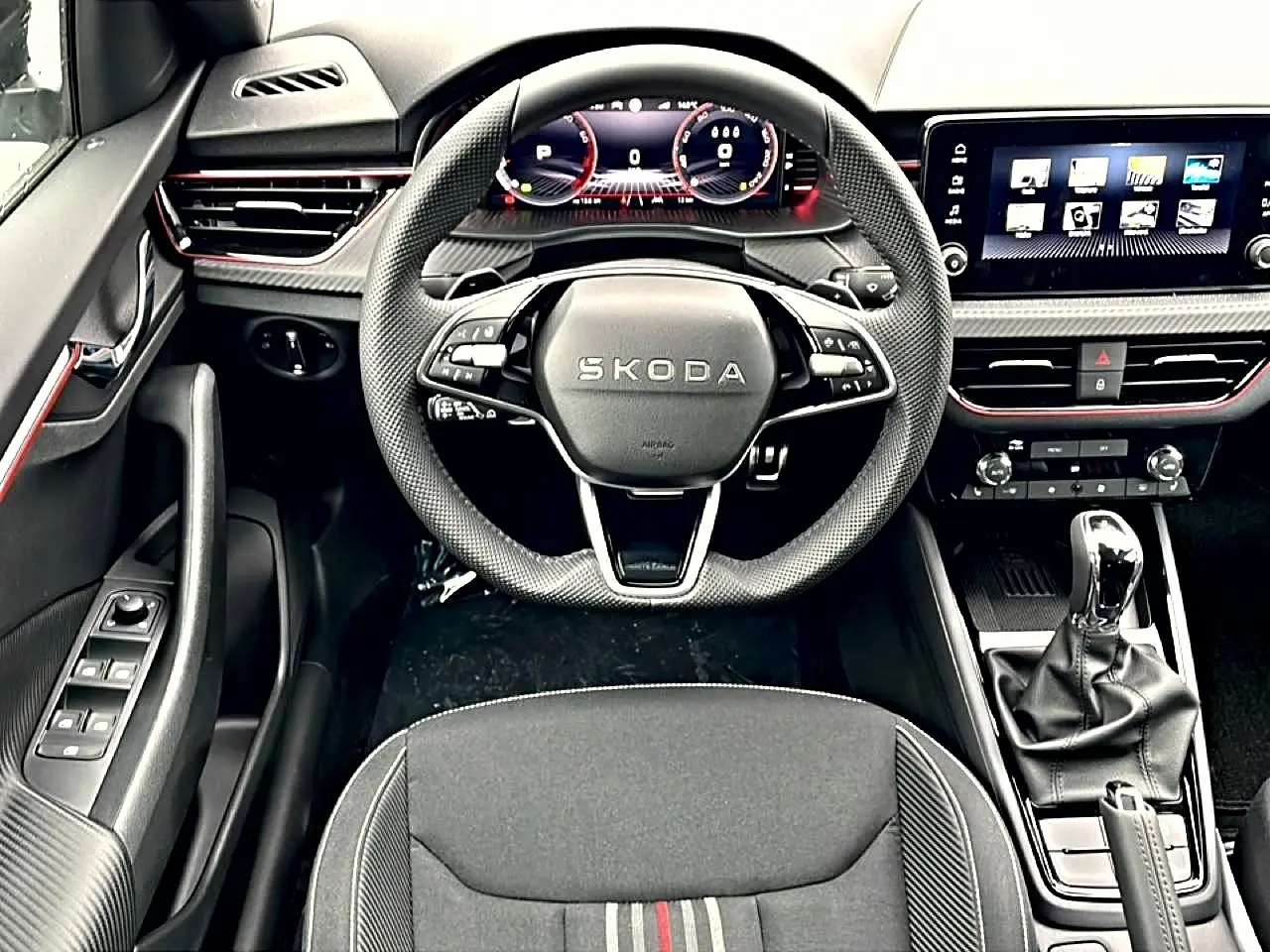 Vue intérieure frontale du poste de conduite du Skoda Kamiq 2026, volant sport et écran tactile multifonction.