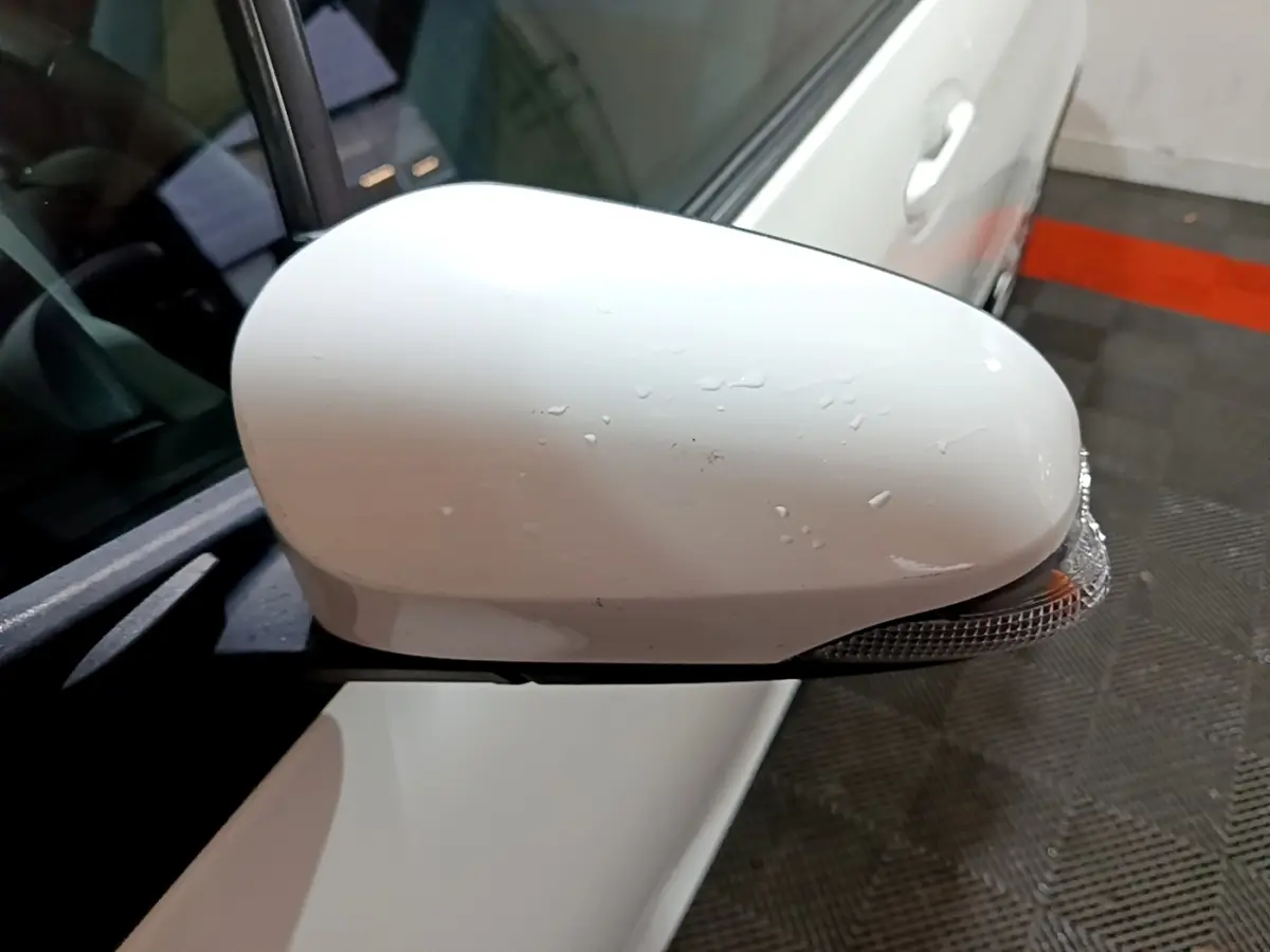 Rétroviseur droit blanc avec clignotant intégré sur Toyota Yaris hybride 2019 vue rapprochée côté conducteur.