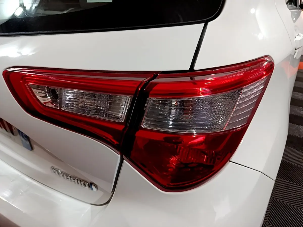 Gros plan sur le feu arrière droit rouge et blanc d'une Toyota Yaris hybride blanche de 2019.