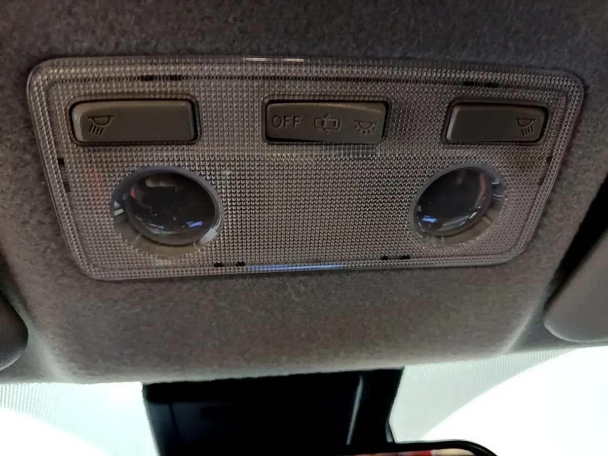 Plafonnier intérieur avec commandes d'éclairage et liseuses dans une Toyota Yaris blanche 2019, vue de dessous.