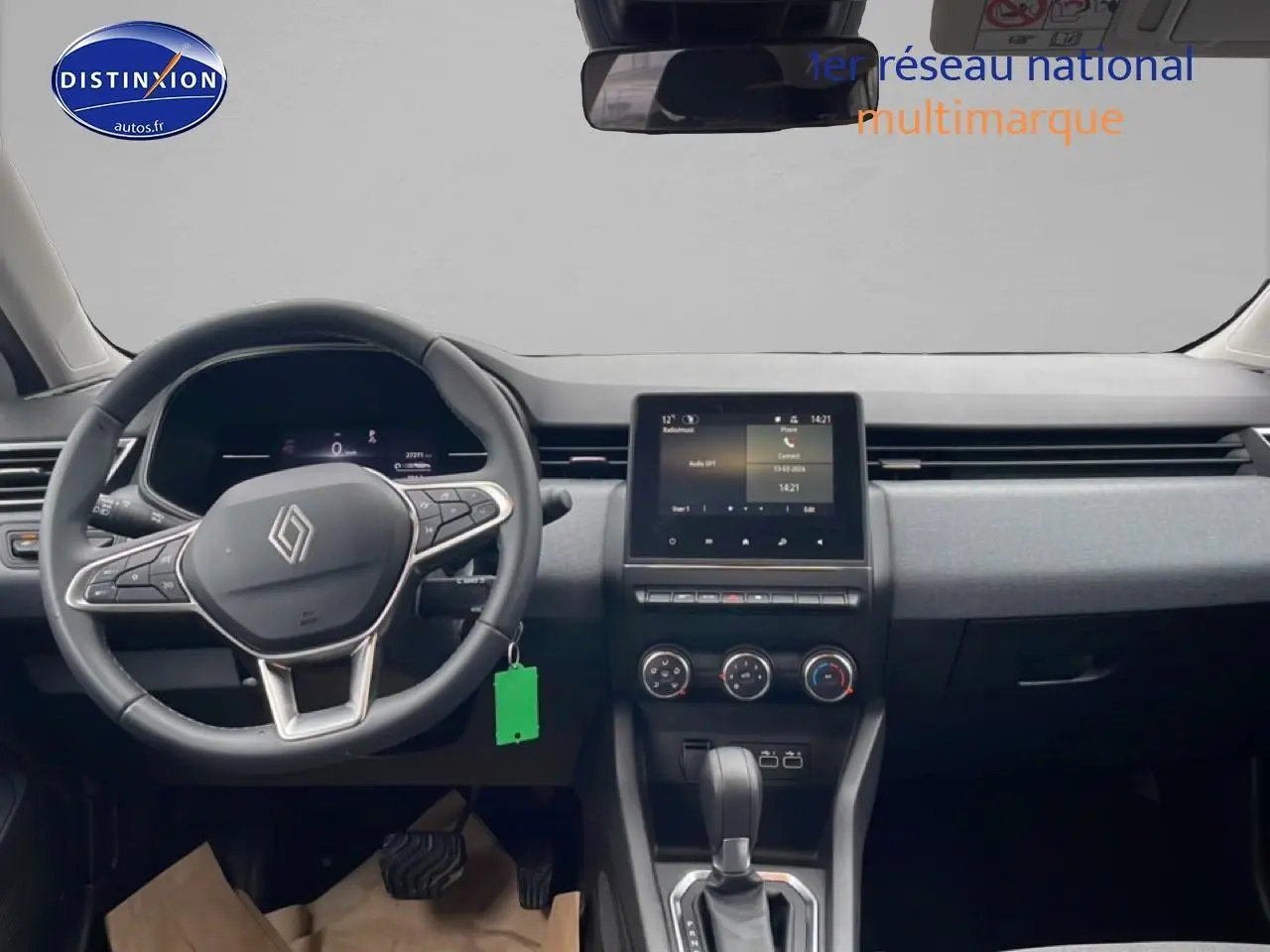 Vue intérieure frontale du tableau de bord et volant noir de la Renault Clio V blanche avec écran tactile central.