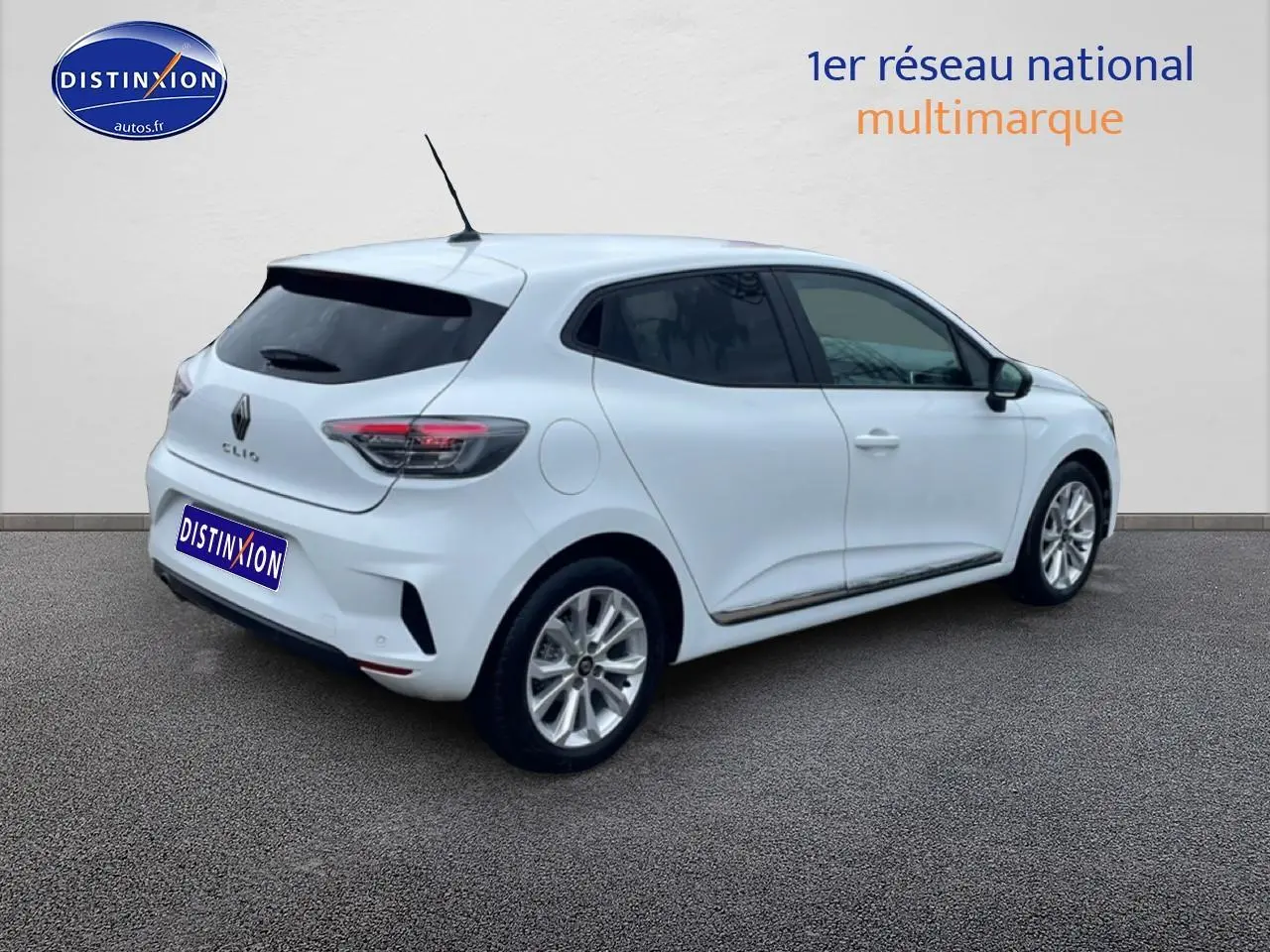 Renault Clio V blanche vue 3/4 arrière droit avec vitres teintées et feux arrière LED allumés.