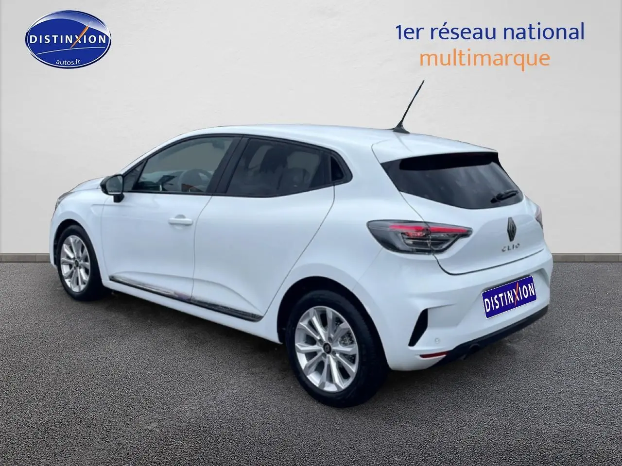 Vue 3/4 arrière droite d'une Renault Clio V blanche avec jantes alliage et vitres teintées.