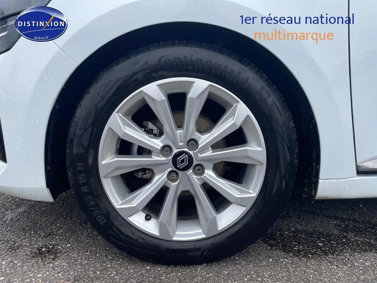 Gros plan sur la roue avant droite avec jante argentée de la Renault Clio V blanche.