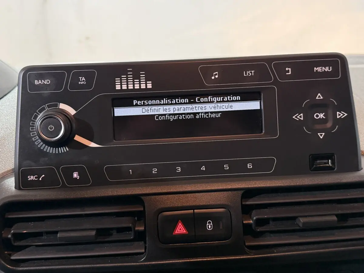 Vue rapprochée du tableau de bord du Peugeot Rifter blanc 2019, affichant l'écran de configuration du système multimédia.