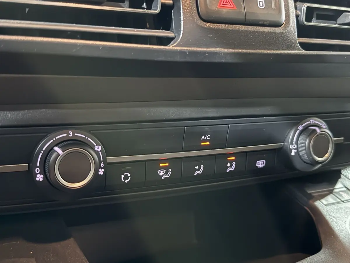 Gros plan sur la commande de climatisation du Peugeot Rifter blanc 2019, avec réglages de ventilation et température visibles.