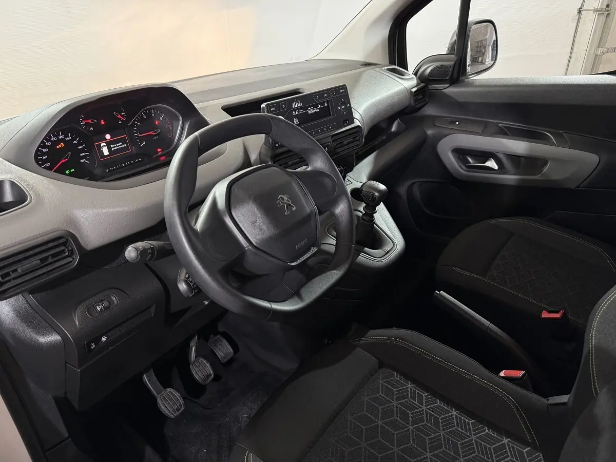 Vue intérieure côté conducteur du Peugeot Rifter 2019, tableau de bord noir avec volant compact et levier de vitesse manuel.