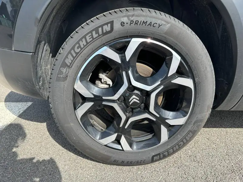 Gros plan sur la roue avant gauche du Citroën C5 Aircross 2025 noir Perla Nera avec jante alliage bicolore et pneu Michelin.