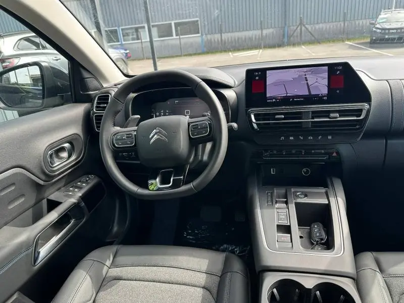 Vue intérieure avant du Citroën C5 Aircross 2025 noir Perla Nera, avec tableau de bord numérique et écran tactile central.