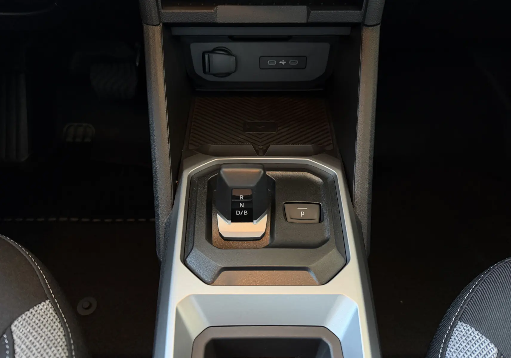Vue rapprochée de la console centrale du Dacia Duster Hybrid 155 Journey 2026, avec levier de boîte automatique noir et gris.