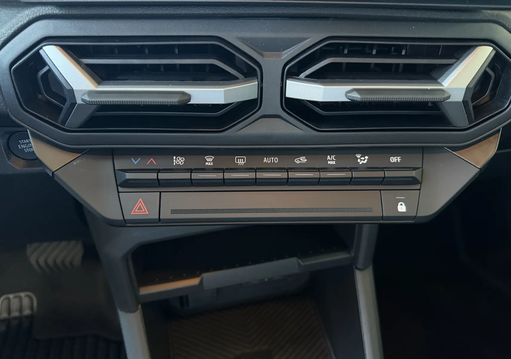 Vue rapprochée de la console centrale du Dacia Duster Hybrid 155 Journey 2026, avec commandes de climatisation et aérateurs noirs.