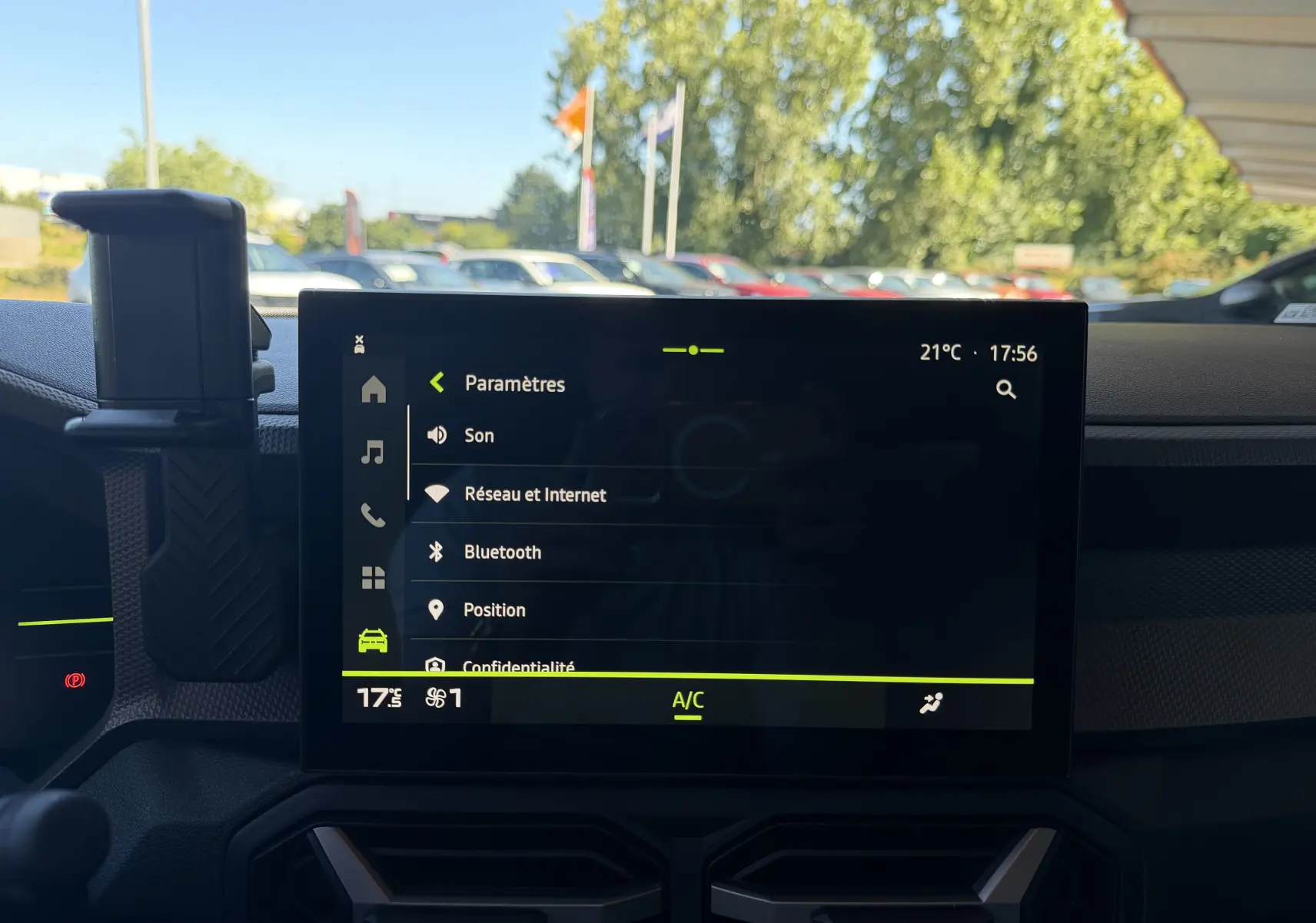 Écran central tactile du tableau de bord du Dacia Duster Hybrid 155 Journey affichant les paramètres connectivité et climatisation.