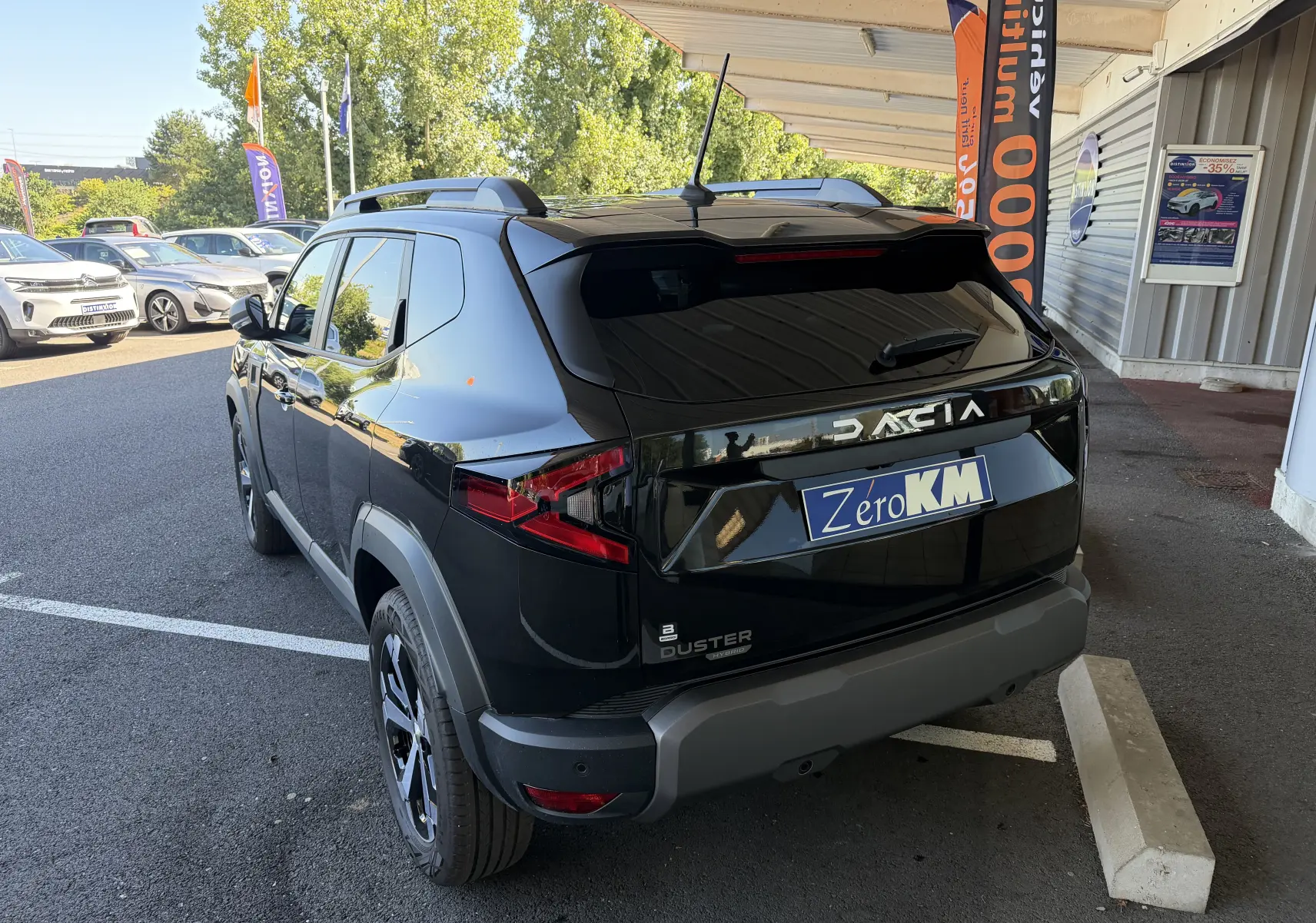 Vue 3/4 arrière droite du Dacia Duster Hybrid 155 noir avec vitres surteintées et jantes alliage 18 pouces en concession.