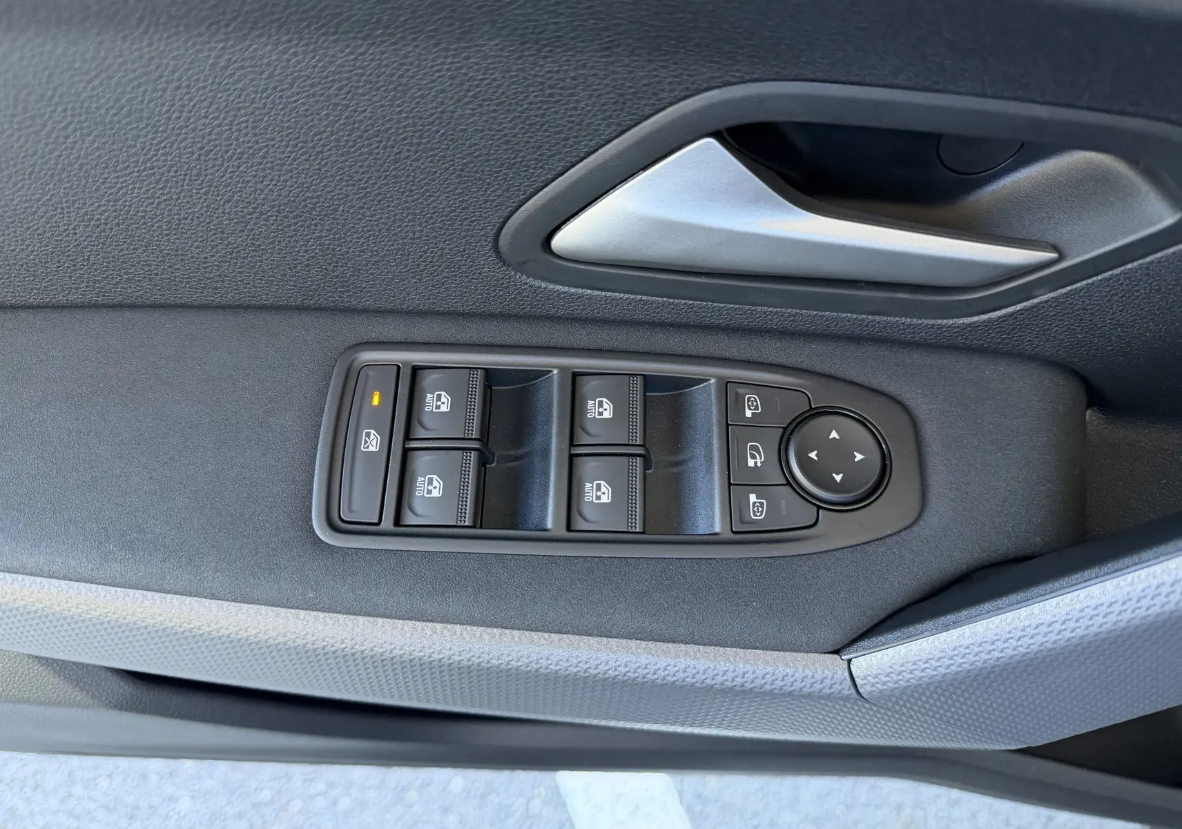 Commande des vitres et réglage des rétroviseurs sur la porte intérieure côté conducteur d'un Dacia Duster noir.