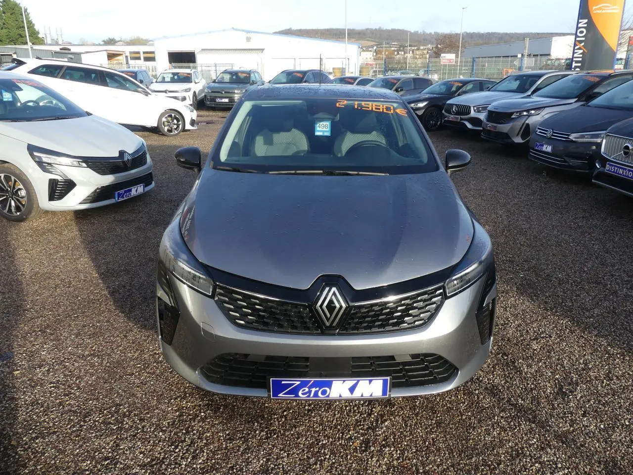 Vue avant d'une Renault Clio 1.5 Blue dCi gris schiste avec calandre noire et logo chromé sur un parking.
