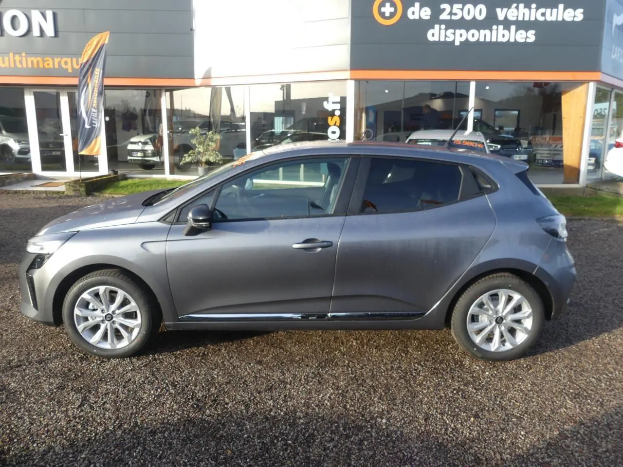 Profil côté gauche d'une Renault Clio gris schiste 2025 avec jantes alliage et vitres teintées.