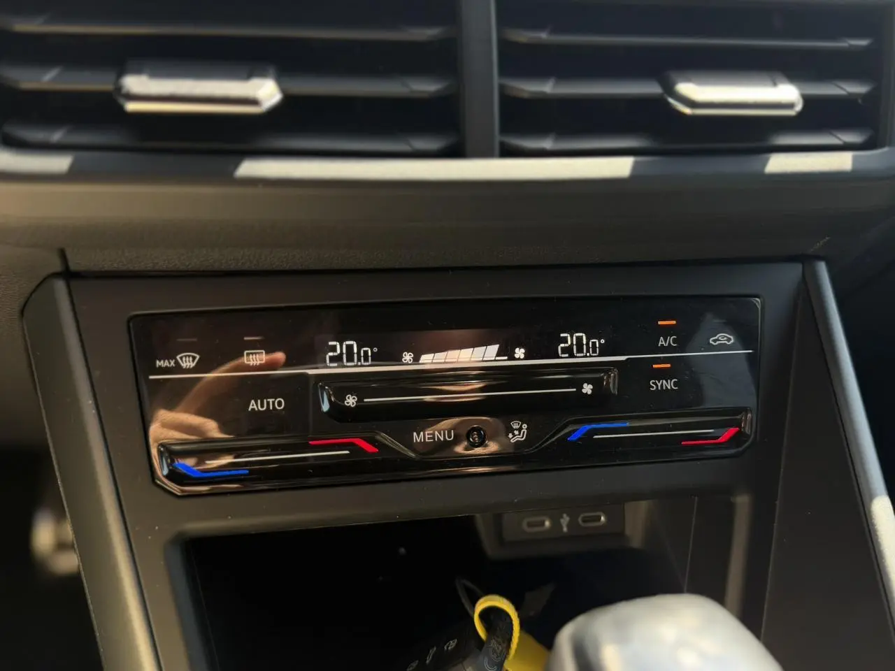 Gros plan sur la commande de climatisation automatique bi-zone du Volkswagen Taigo noir, affichant 20°C des deux côtés.