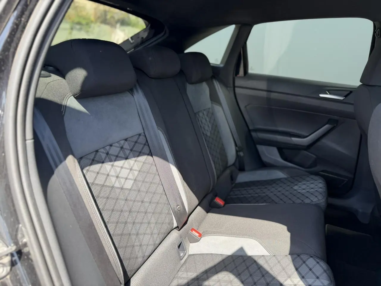 Vue côté droit de la banquette arrière noire avec sellerie tissu R-Line et motifs géométriques dans un Volkswagen Taigo 2025.