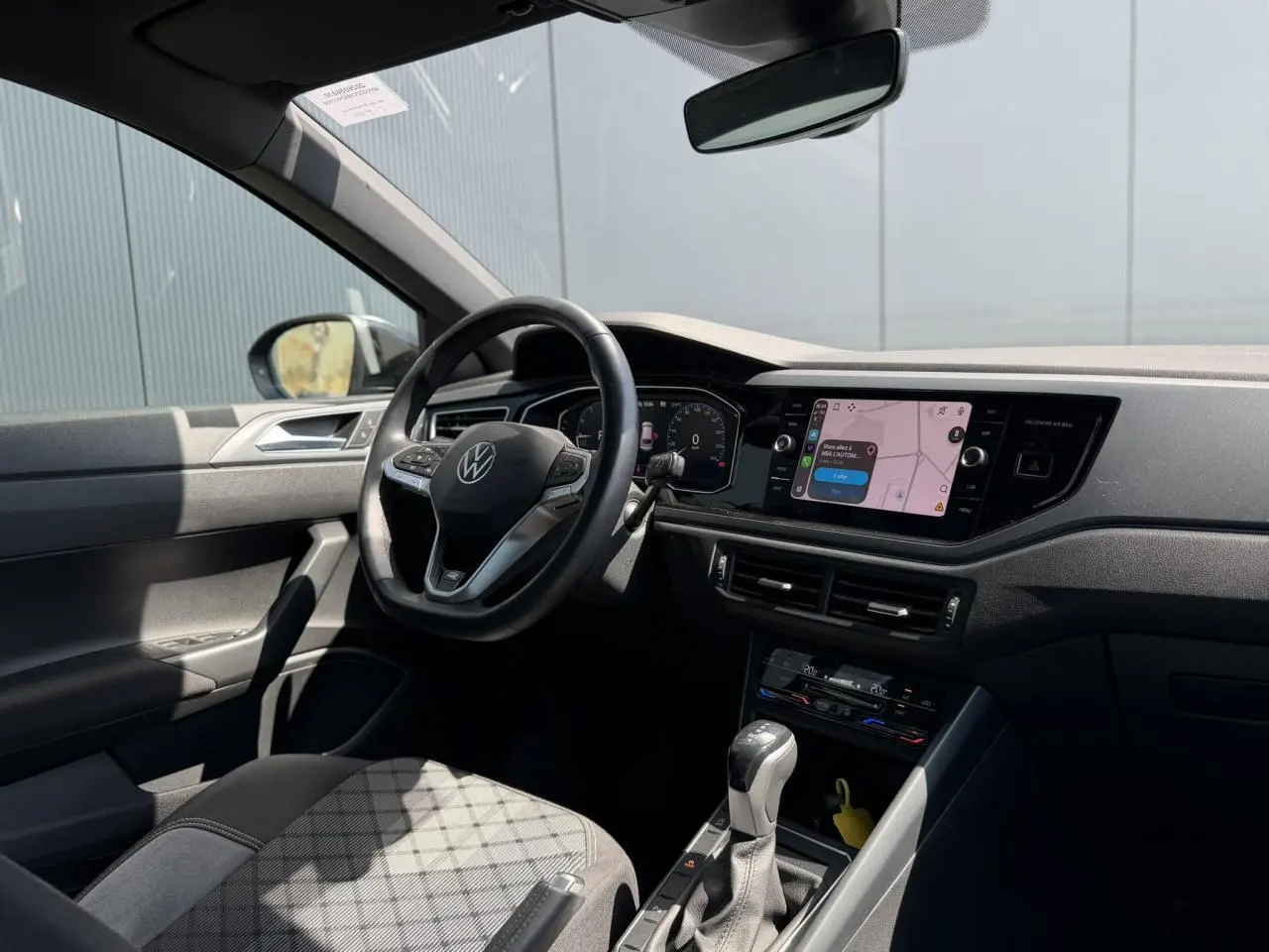Intérieur du Volkswagen Taigo TSI 116 DSG R-Line 2025 vu côté conducteur, avec volant cuir et écran tactile.
