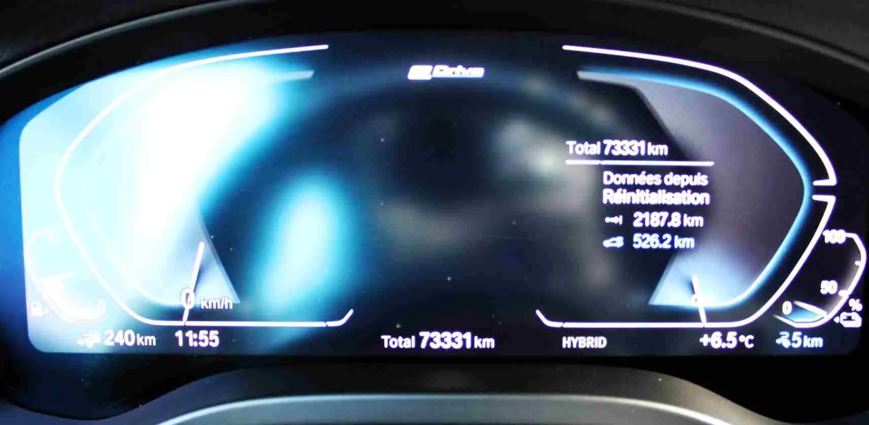 Tableau de bord numérique du BMW X3 xDrive 30e 2023 affichant 73 331 km, température et autonomie hybride.