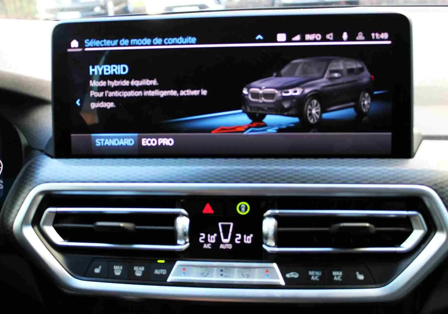 Écran central du BMW X3 xDrive 30e 2023 affichant le mode hybride avec vue 3/4 avant du SUV bleu métal.