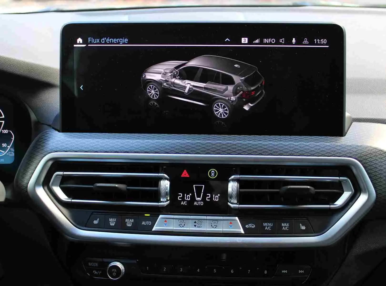 Écran central du BMW X3 xDrive 30e 2023 montrant le flux d'énergie hybride, avec commandes climatisation en dessous.
