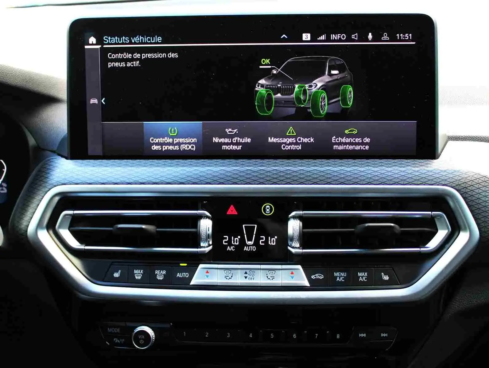 Écran central du tableau de bord du BMW X3 xDrive 30e 2023 montrant le contrôle pression pneus avec interface moderne.