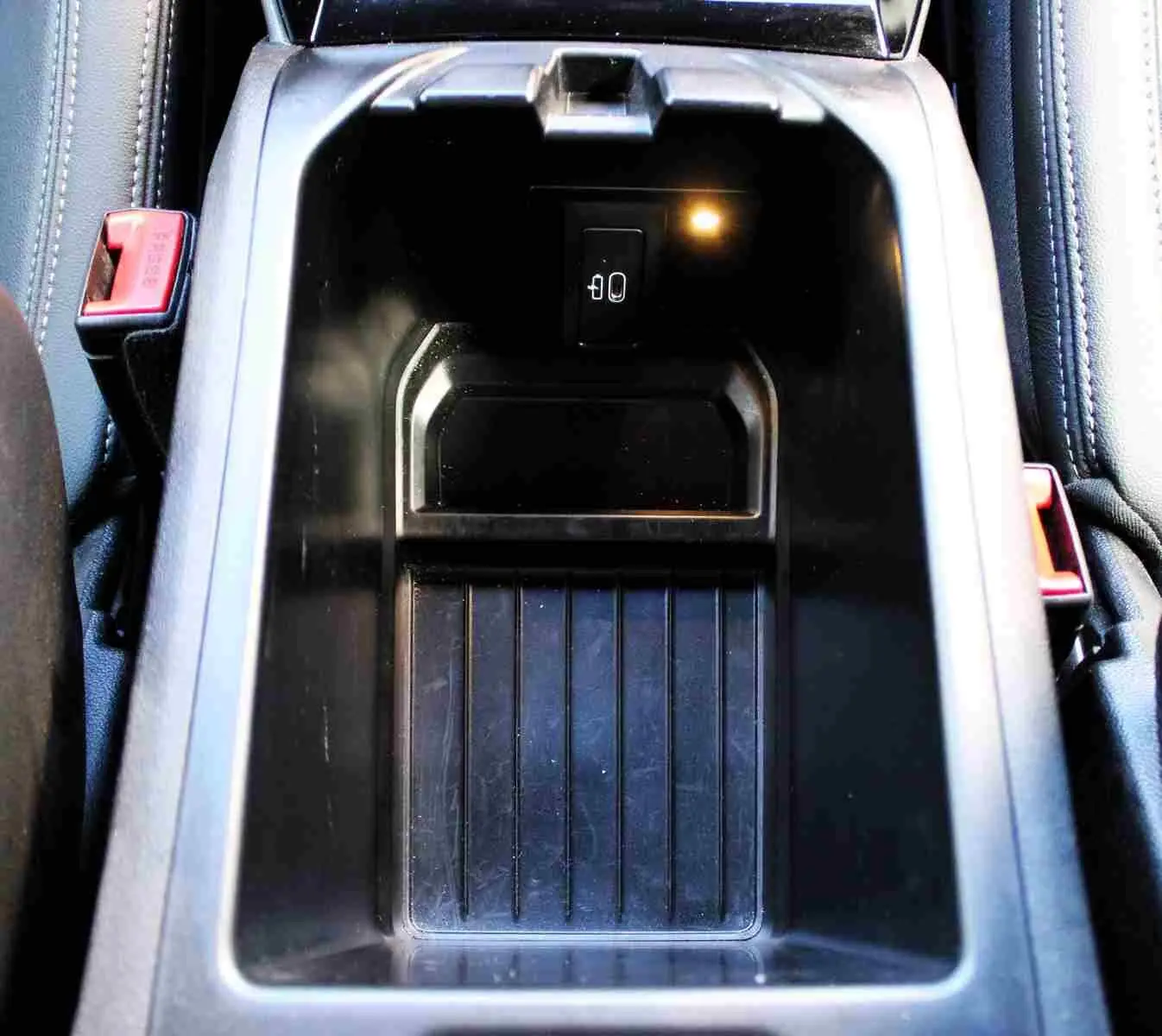 Gros plan sur le rangement central noir du BMW X3 xDrive 30e 2023, avec prise USB visible à l'intérieur.