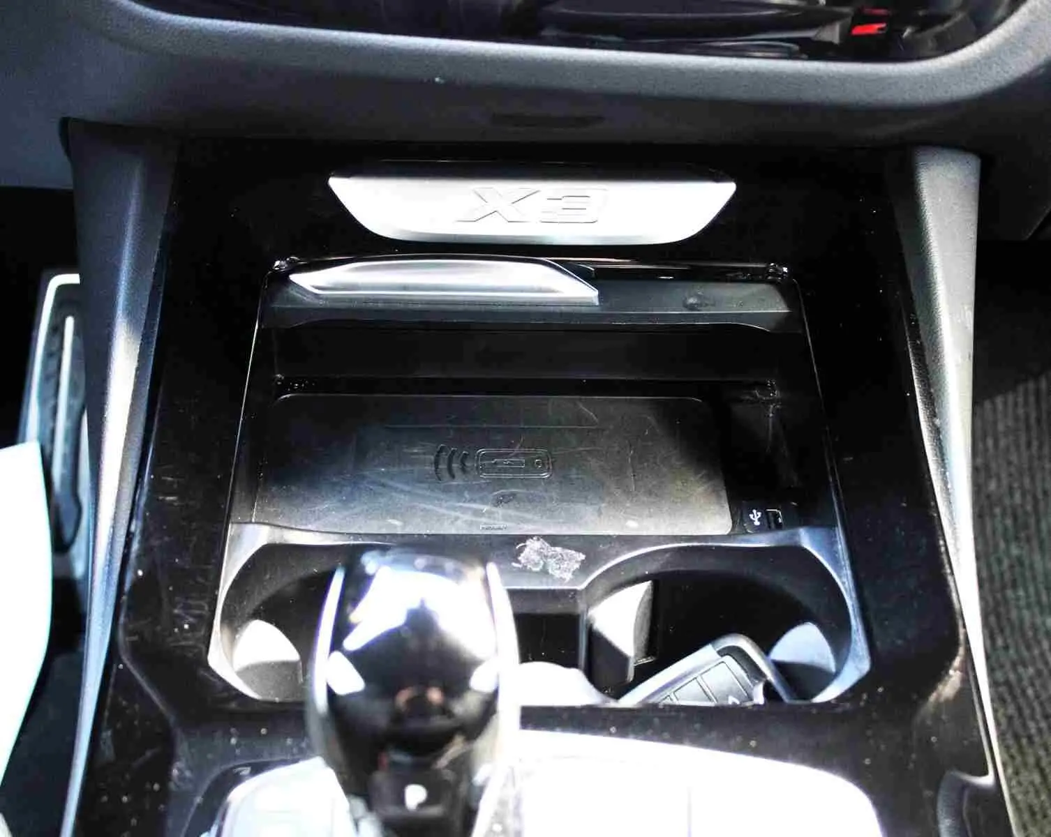 Gros plan sur la console centrale du BMW X3 xDrive 30e 2023 avec levier de vitesses et logo X3 en relief.