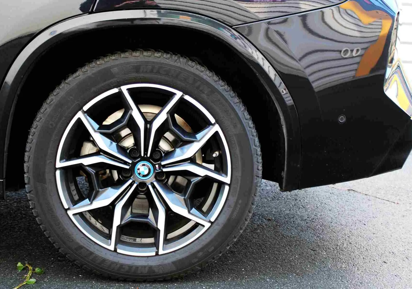 Gros plan sur la roue arrière droite noire avec jante alliage au design complexe du BMW X3 xDrive 30e 2023.