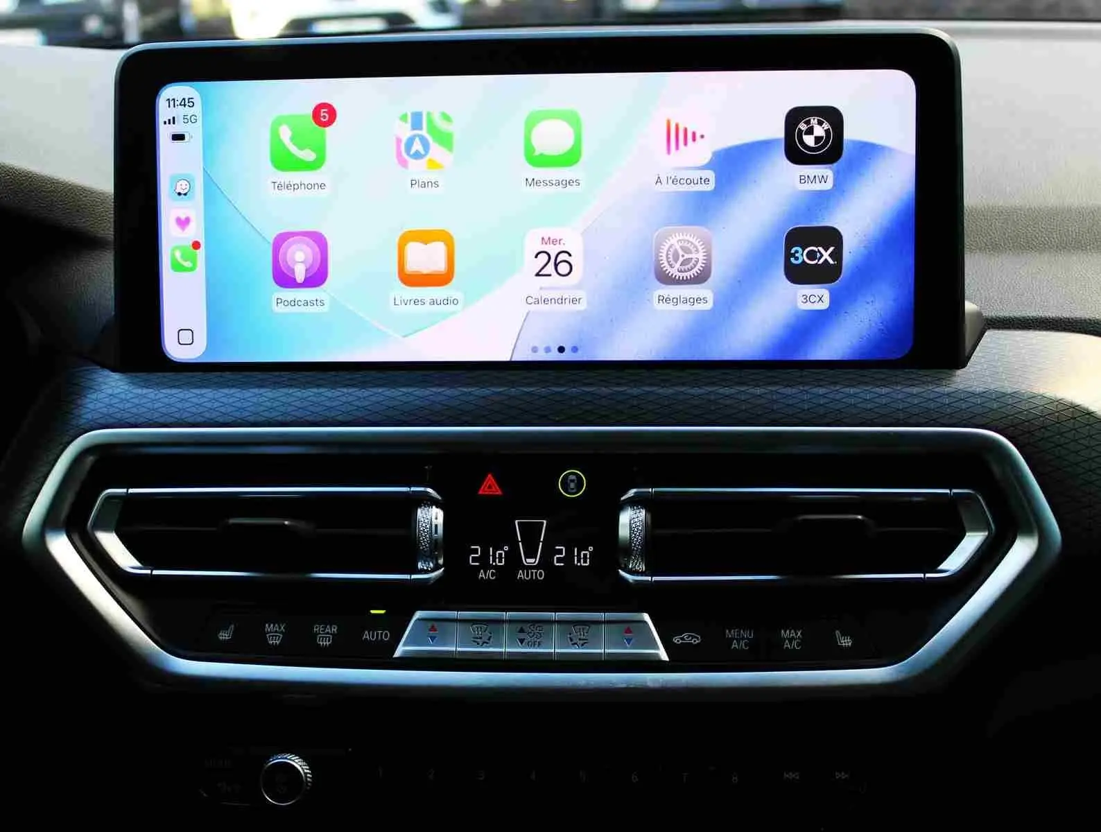 Écran tactile central et commandes de climatisation du BMW X3 xDrive 30e 2023, intérieur moderne et épuré.